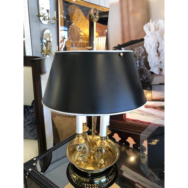 A gorgeous cast brass bouillotte style table lamp having ornate serpeants that hold up four candle arms with original...