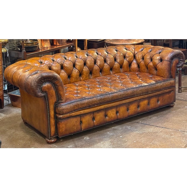 A fine, large Chesterfield sofa upholstered in original patinated chestnut leather from the Edwardian era - featuring a...