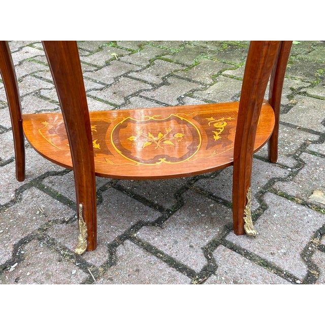 Bring timeless French sophistication into your home with this elegant Louis XVI-style side table, crafted circa 1980 by a...