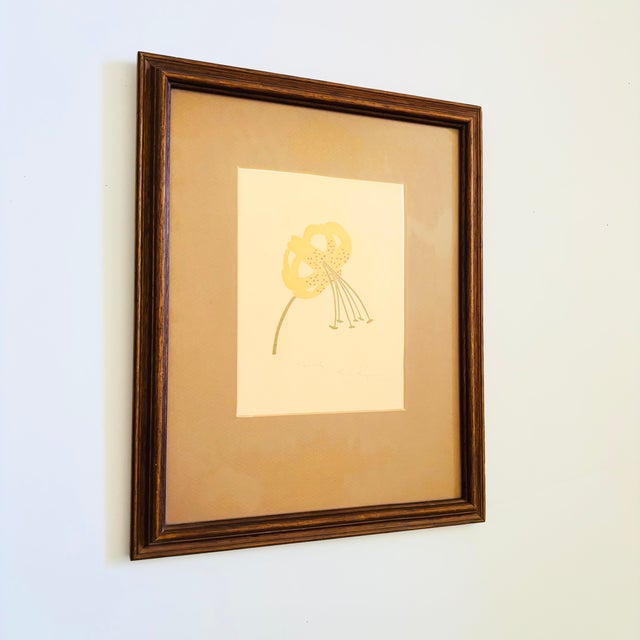 A vintage original serigraph featuring the image of a tiger lily in yellow tones with red dots and a green stem and...