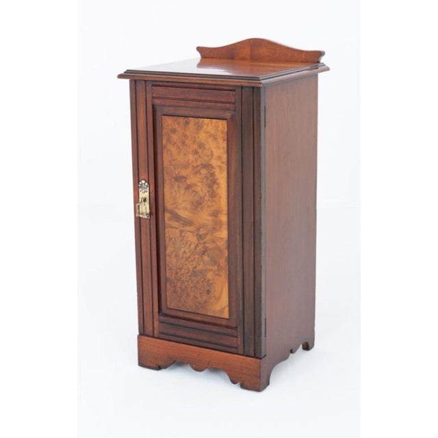 Late Victorian walnut bedside cabinet This cabinet stands upon a plinth base Circa 1900 The door featuring a wonderful...