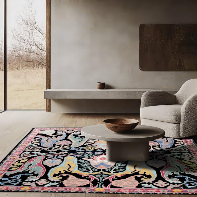 A hand-knotted wool rug, made in India and measuring 8' x 10'. Floral drawing carried across the field inside a...