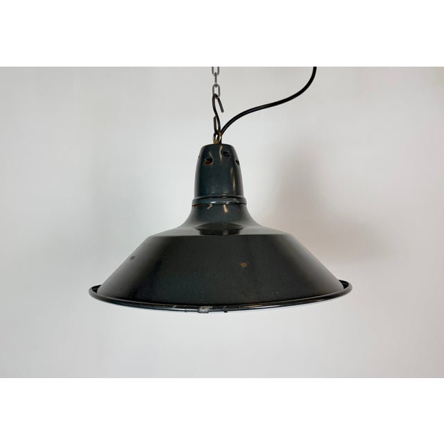 Industrial black enamel pendant light made in France during the 1960s. White enamel inside the shade. Metal top. The...