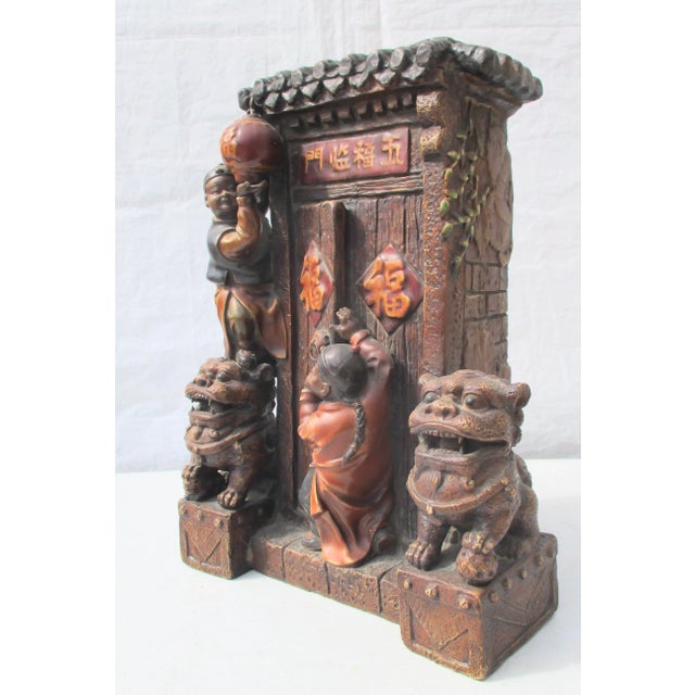 Absolutely charming vignette of two boys putting up lanterns at a doorway. Obviously Chinese door with guardian foo lions...