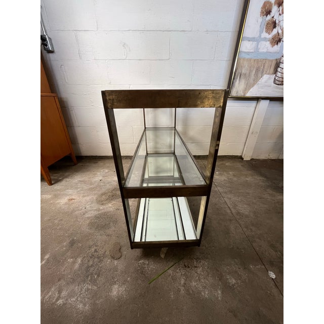 An entertainer's dream, simple yet sophisticated. A stunning, high quality bronze, glass and mirror mid century bar cart...
