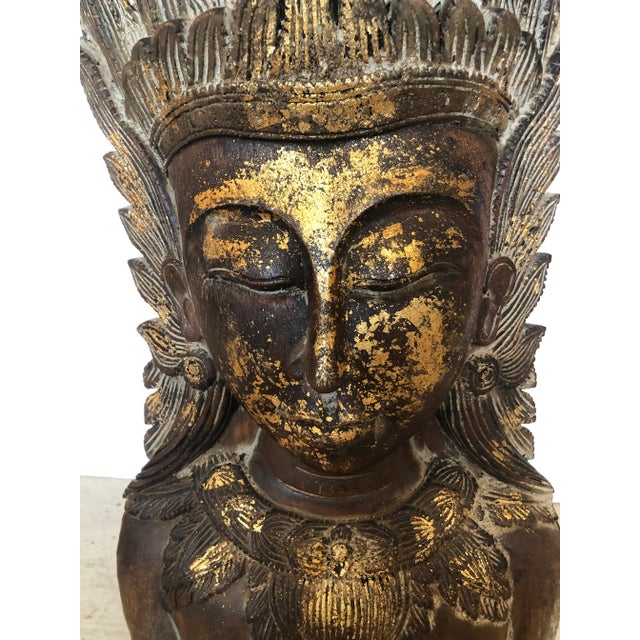 Dramatic and impressively large carved and gilded wooden sculpture of a Thai female bust having ornate head dress....