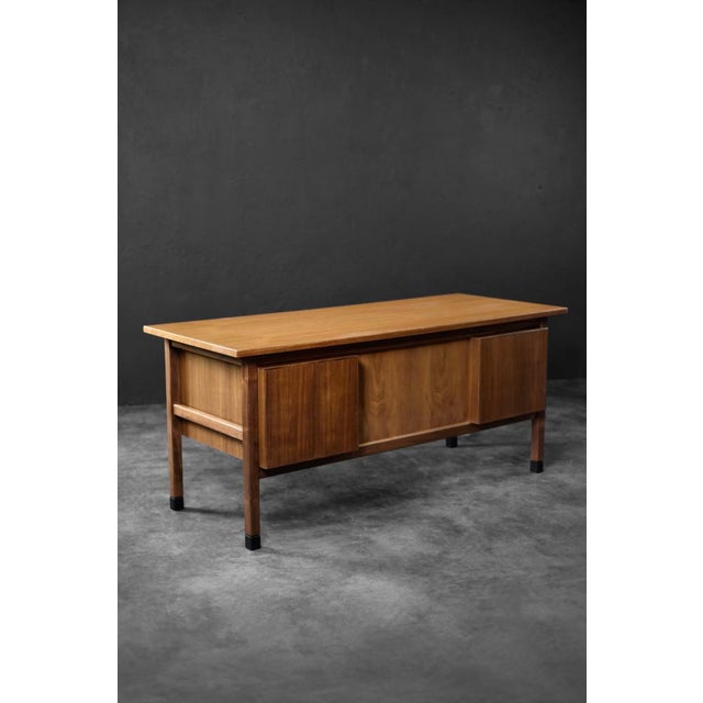 This modernist desk was manufactured in Denmark during the 1960s. It is finished in natural teak wood in a warm shade of...