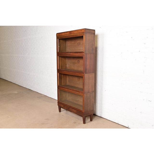 A gorgeous antique Arts & Crafts four-stack barrister bookcase By Macey USA, circa 1920s Oak, with glass front doors and...