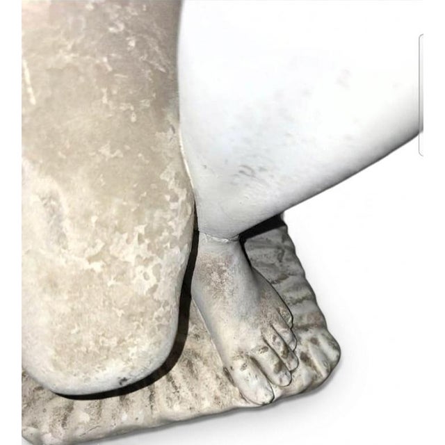 This sculpture is a depiction of the Crouching Venus (also known as Venus Accroupie or Crouching Aphrodite), a famous...