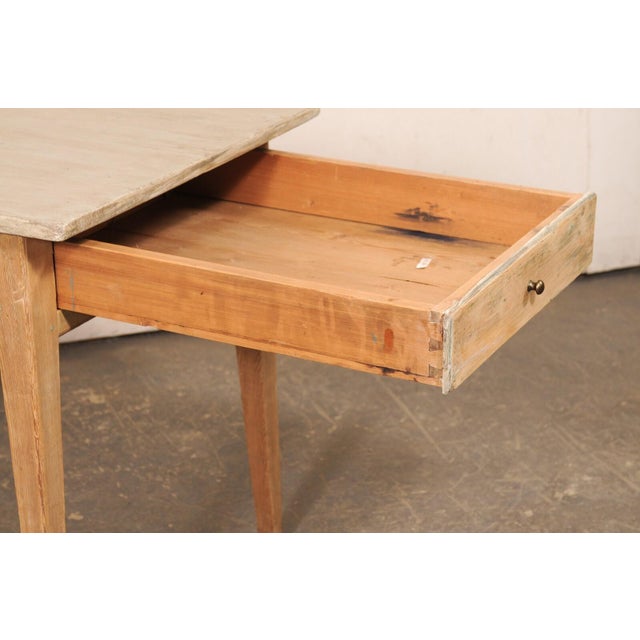 A Swedish smaller-sized wooden table, with single drawer, from the 19th century. This antique table from Sweden has a...