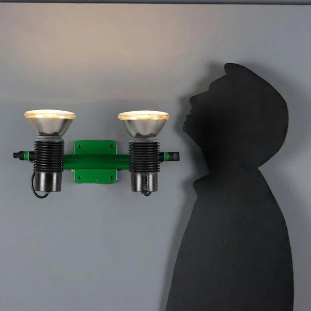 Wall lamp in green enamelled metal and plastic material with two adjustable light points. This piece is attributed to the...