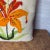Handcrafted needlepoint pillow of a lily. It may not be a lily, I’m terrible at identifying flowers. The face of the...