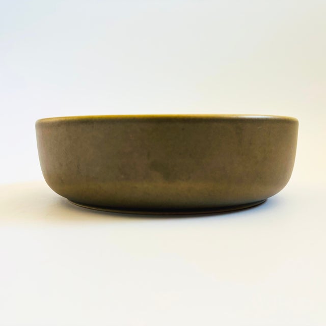 A vintage circular ceramic serving bowl. Lovely olive green exterior glaze with a speckled white interior glaze. Measures...