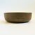 A vintage circular ceramic serving bowl. Lovely olive green exterior glaze with a speckled white interior glaze. Measures...