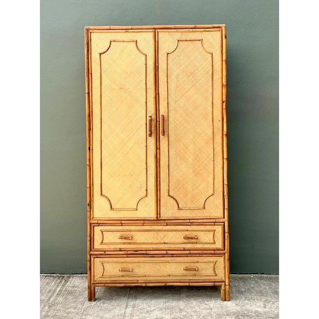 This vintage bamboo and rattan armoire pairs tropical, organic materials with a clean, architectural silhouette, ideal for...