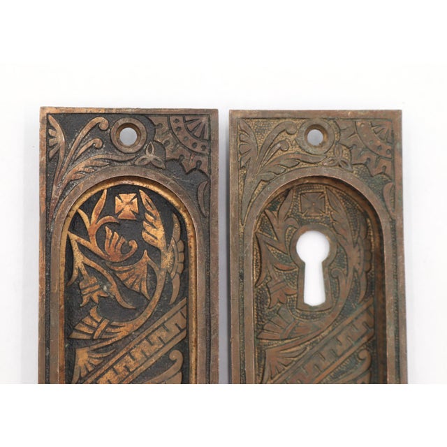Antique Eastlake style recessed pocket door pulls made of brass with a patina finish. The original mounting screws are not...