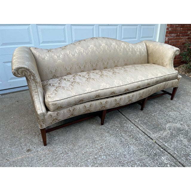 Vintage 1980s era camelback sofa, reupholstered in a beautiful golden cream silk/poly blend damask fabric. Down-filled,...