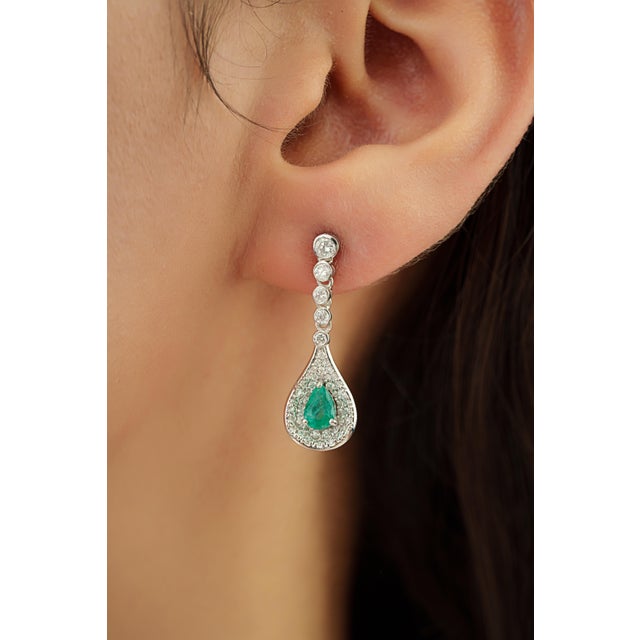 These dangle earrings feature 0.79 carats of pear-shaped emeralds set in 14K white gold. Each emerald measuring 3.8 x 5.8...