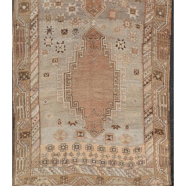 Measures: 5' x 13'5" Antique Turkish Kars Oushak Gallery Rug with Geometric Medallion Design in Soft Earth Tones. Keivan...