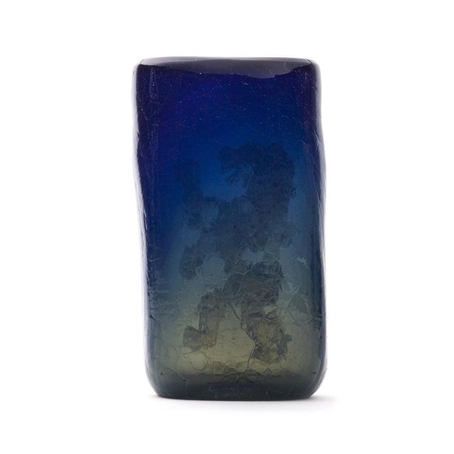 This remarkable product of artistic handcraft is made of dark blue glass with parts of semi-transparent greys. The vase is...