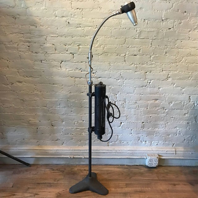 Industrial, machine age, optical, medical floor lamp by Bausch & Lomb features a cast iron base with height adjustable,...
