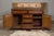 An English oak dresser base from the 19th century with geometric front, five drawers, two doors and brass hardware....