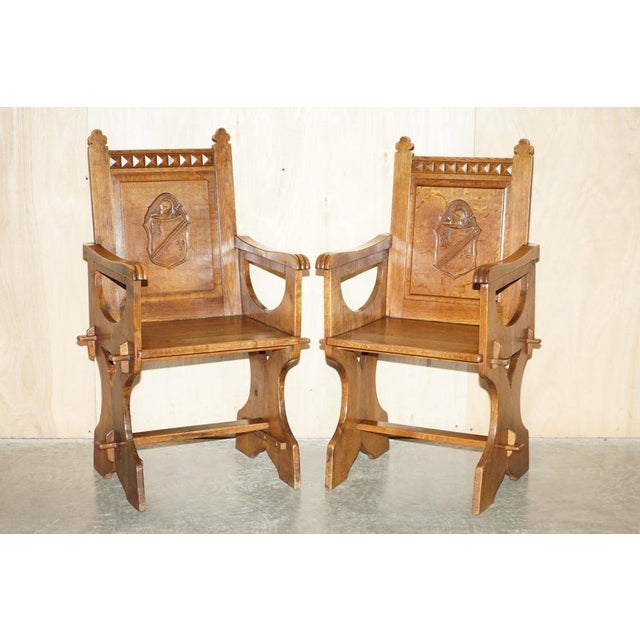 We are delighted to offer for sale this stunning pair of antique English oak hand carved chairs with Armorial coat of arms...