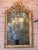 An exceptional Italian Baroque mirror featuring a richly carved giltwood frame with an elegant arched silhouette and an...