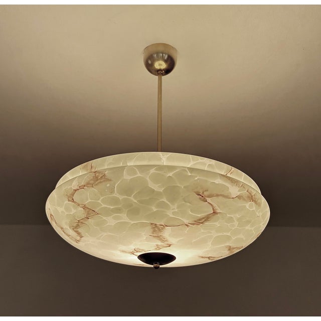 large Art Deco pendant lamp with a green mottled marble glass shade with darker veins and patches, brass suspension and...