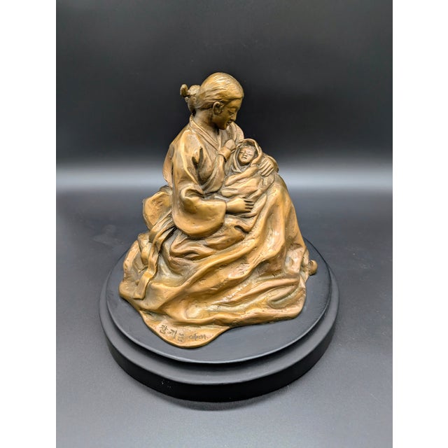 Traveling Man Treasures is selling this gorgeous vintage Korean bronze sculpture of a seated Korean woman holding a baby...
