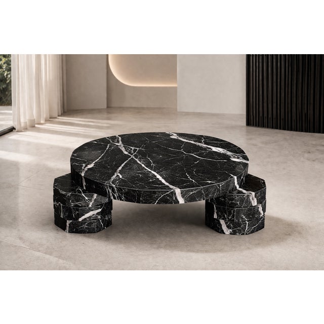 A sculptural coffee table crafted from fine Nero Marquinia marble, entirely handcrafted in Italy. The perfectly round top...
