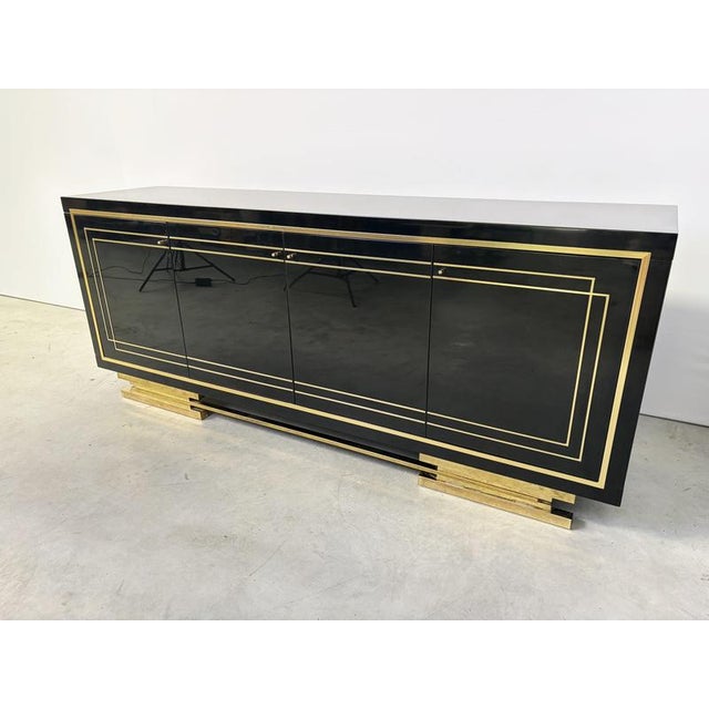 Luxurious sideboard made from shiny black lacquer and brass hardware. This high end sideboard is very much in the style of...