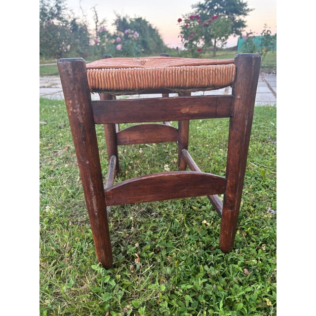 A charming country bench, a discreet reminder of early 20th-century french rural life. its dark solid wood frame—oak or...