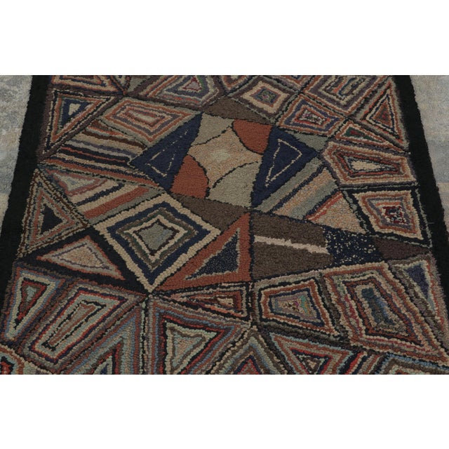 This antique 3x5 hooked rug, circa 1920–1929, features an expressive geometric visual juxtaposition of angular motifs and...