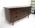 A rich dark walnut nine drawer dresser chest with smaller drawers to the center and cut out pulls. This studio styled...
