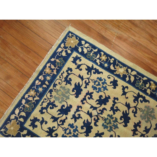 An early 20th century Chinese peking throw rug. Cream field with blue accents. 3' x 5'10''