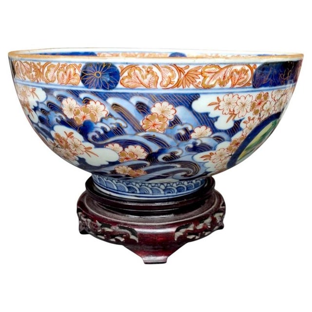 A large and richly decorated Japanese Arita Imari porcelain bowl dating to the late Edo period. The bowl displays the...