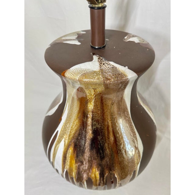 Mid century drip glaze pottery lamp. Brown body with drip glaze in shades of brown, tan, and white. Small surface...