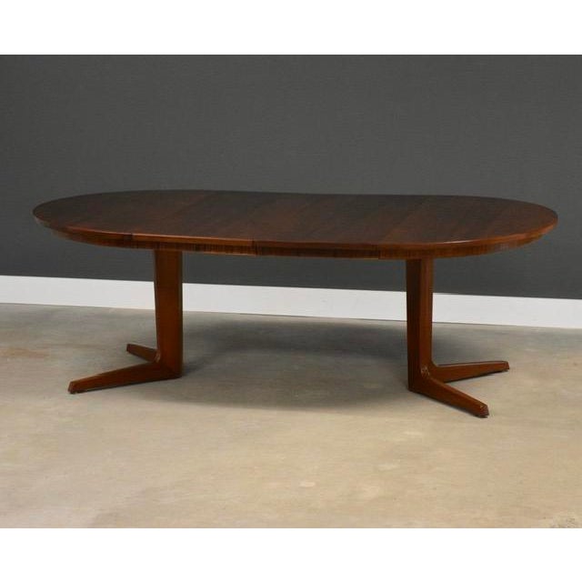 A mid century modern teak round to oval dining table with two 19.125” leaves and a pedestal base by BPS. Made in Denmark....