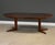 A mid century modern teak round to oval dining table with two 19.125” leaves and a pedestal base by BPS. Made in Denmark....
