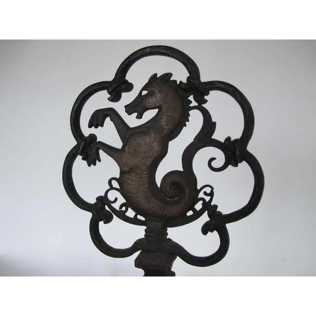 A pair of stylized, sea-horse andirons by Oscar Bach.