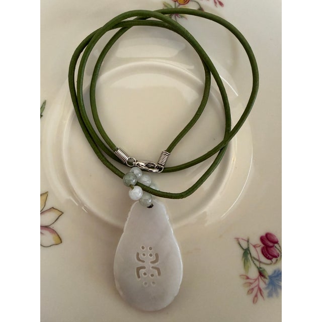Hand-carved, gourd-shaped jade pendant necklace, crafted from a highly translucent, icy white-to-pale-lavender jadeite...