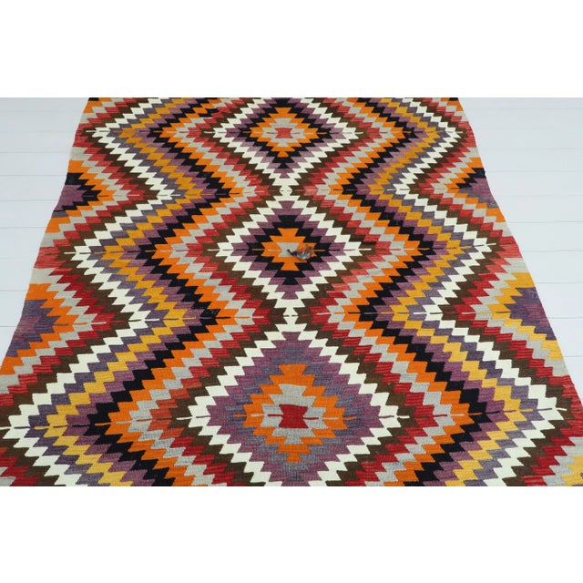 This Turkish Kilim rug hosts an intriguing pallet of vibrant rich and pastel colorways complementing a very turkish sense...