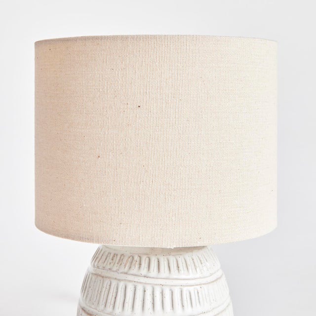 A ceramic base, this little lamp has a speckled, reactive glaze that plays off the carved meandering pattern. Topped with...