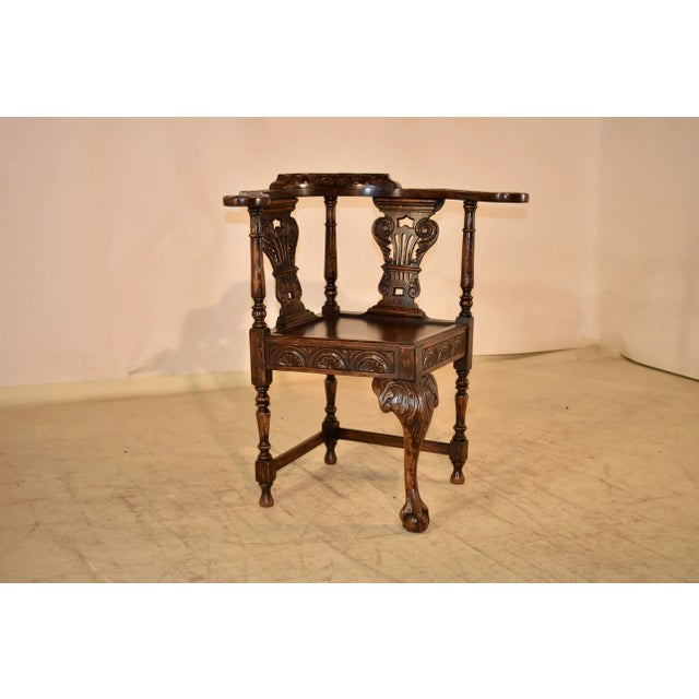 19th century oak corner chair from England. The arms and back of the chair are wonderfully barrel shaped and embellished...