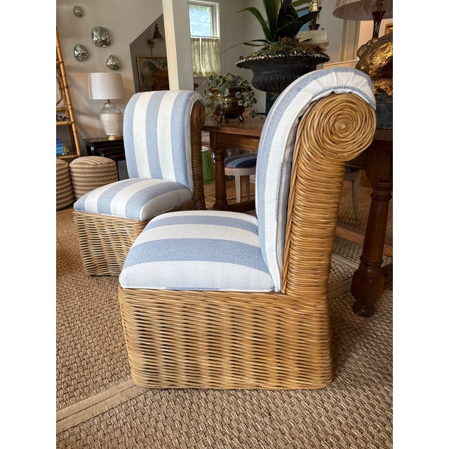 Set of two woven rattan slipper chairs newly upholstered in a crisp, timeless blue-and-white cabana stripe fabric. The...