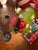 Pure Fun! Bobble Head Santa with greenery reins, riding a reindeer with a green sweater and white polka dots and twigs...