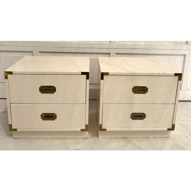 Here is a great pair of campaign style nightstands from the 1970's. The pieces are white with patinated deep brass...