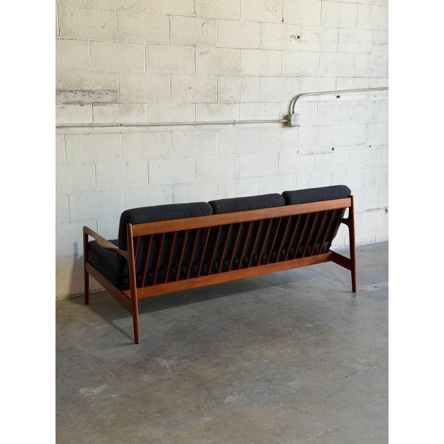 This elegant 3 seater sofa presents an open frame with gently sculpted armrests and a spindle back. The clean lines...
