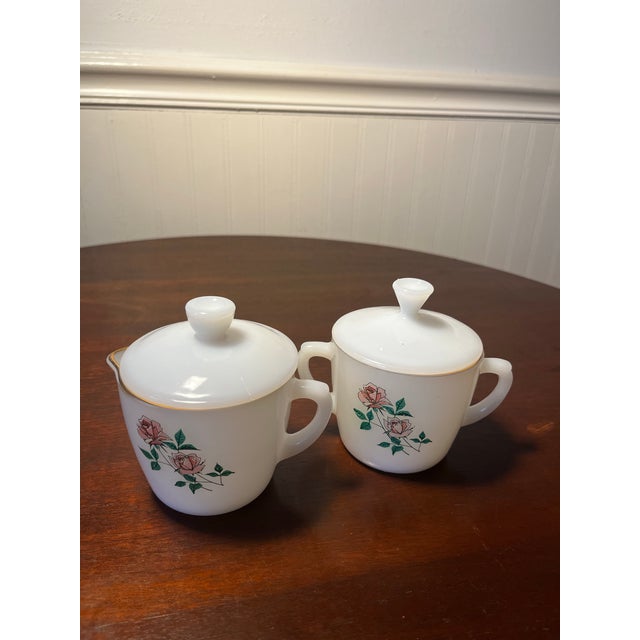 White milk glass creamer & sugar set by Fire-King with The pattern “ Anniversary Rose”. Both have lids . Produced in 1964....